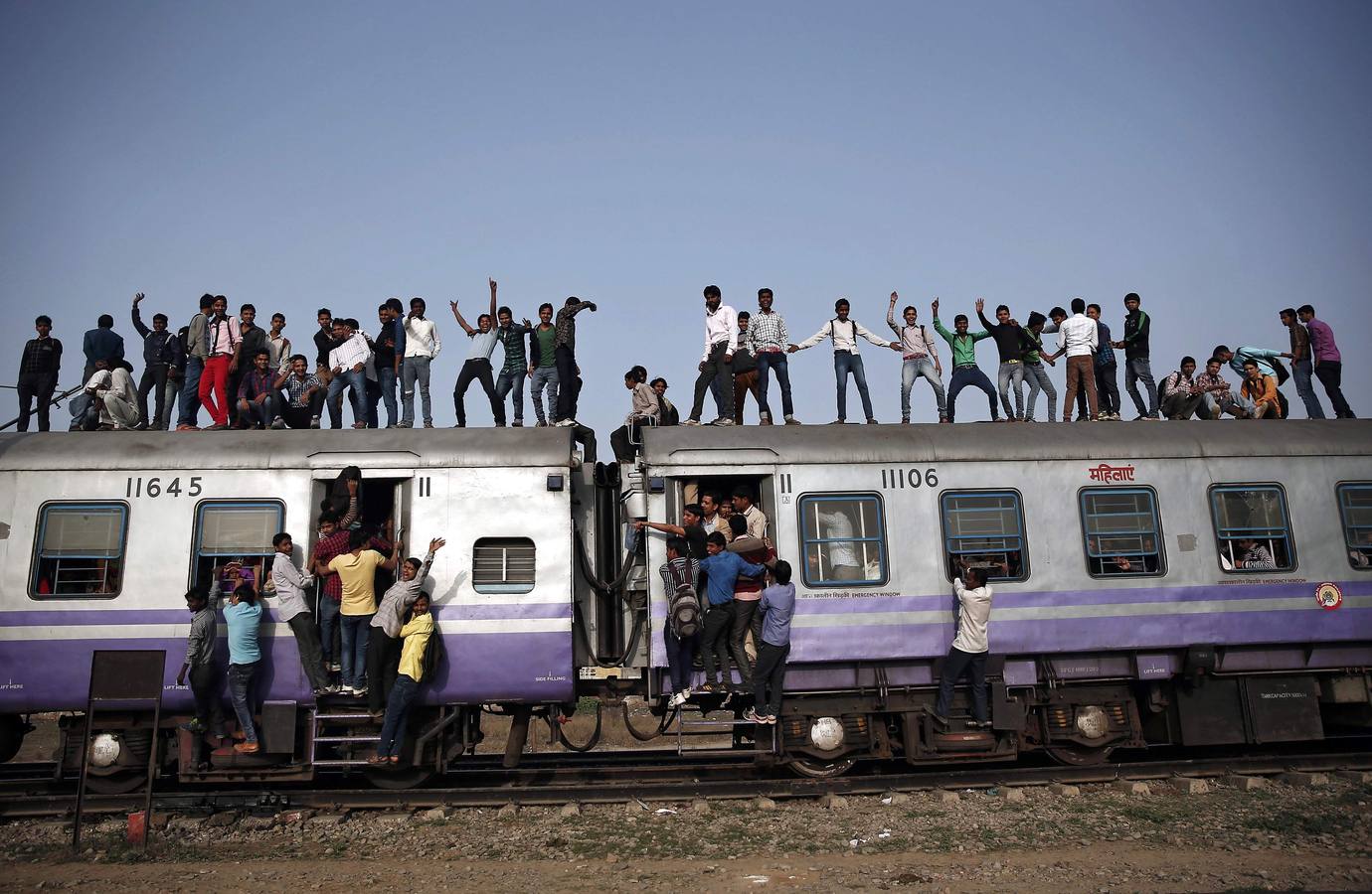 Los pasajeros viajan en un tren abarrotado en las afueras de Nueva Delhi