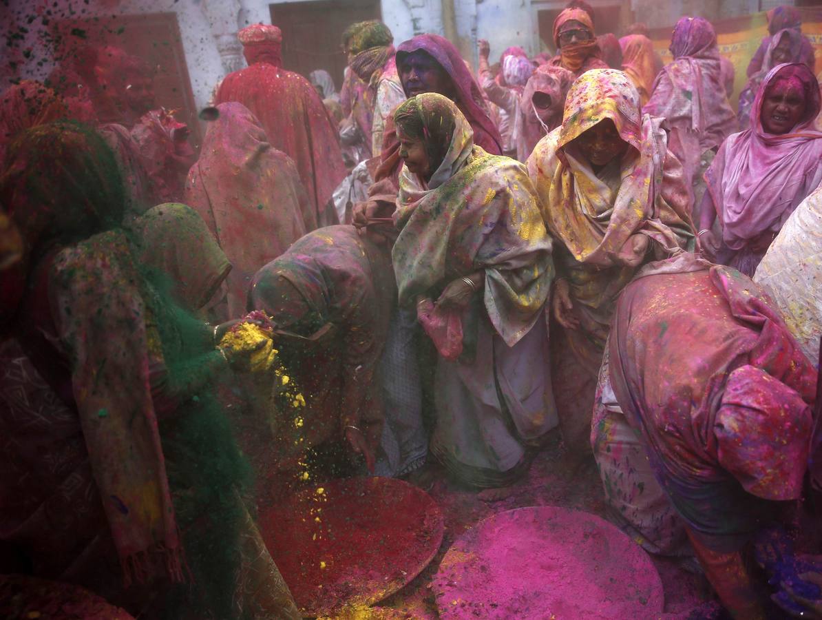 Mujeres viudas de Vrindavan pintarrajeadas en colores toman parte en las celebraciones de Holi, organizado por la organización no gubernamental Sulabh Internacional. Fotografía: Reuters / Ahmad Masood.