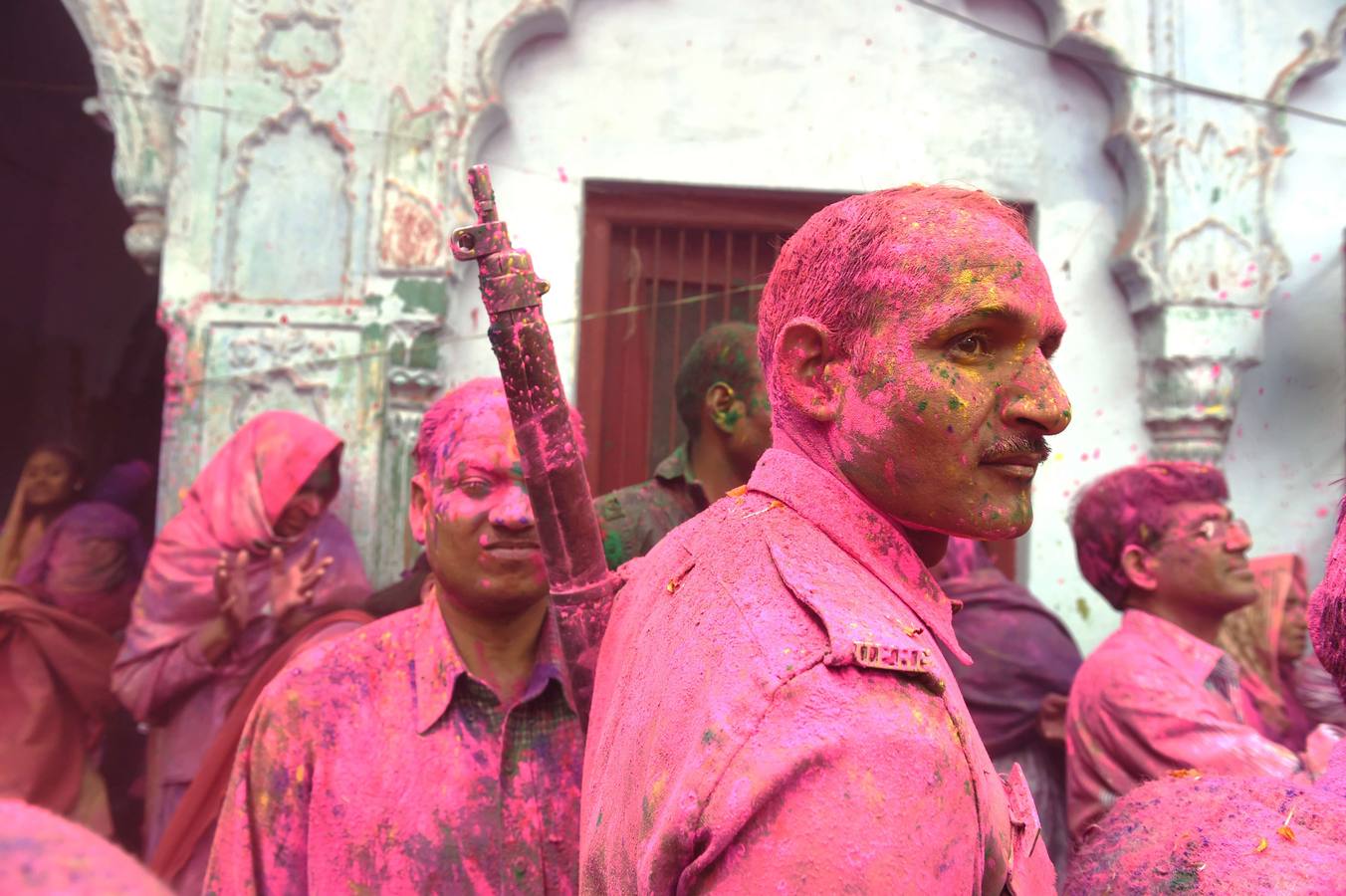 Un policía hindú cubierto en polvo de color rosa mientras visita las celebraciones de Holi en Vrindavan. Fotografía: AFP / Roberto Schmidt