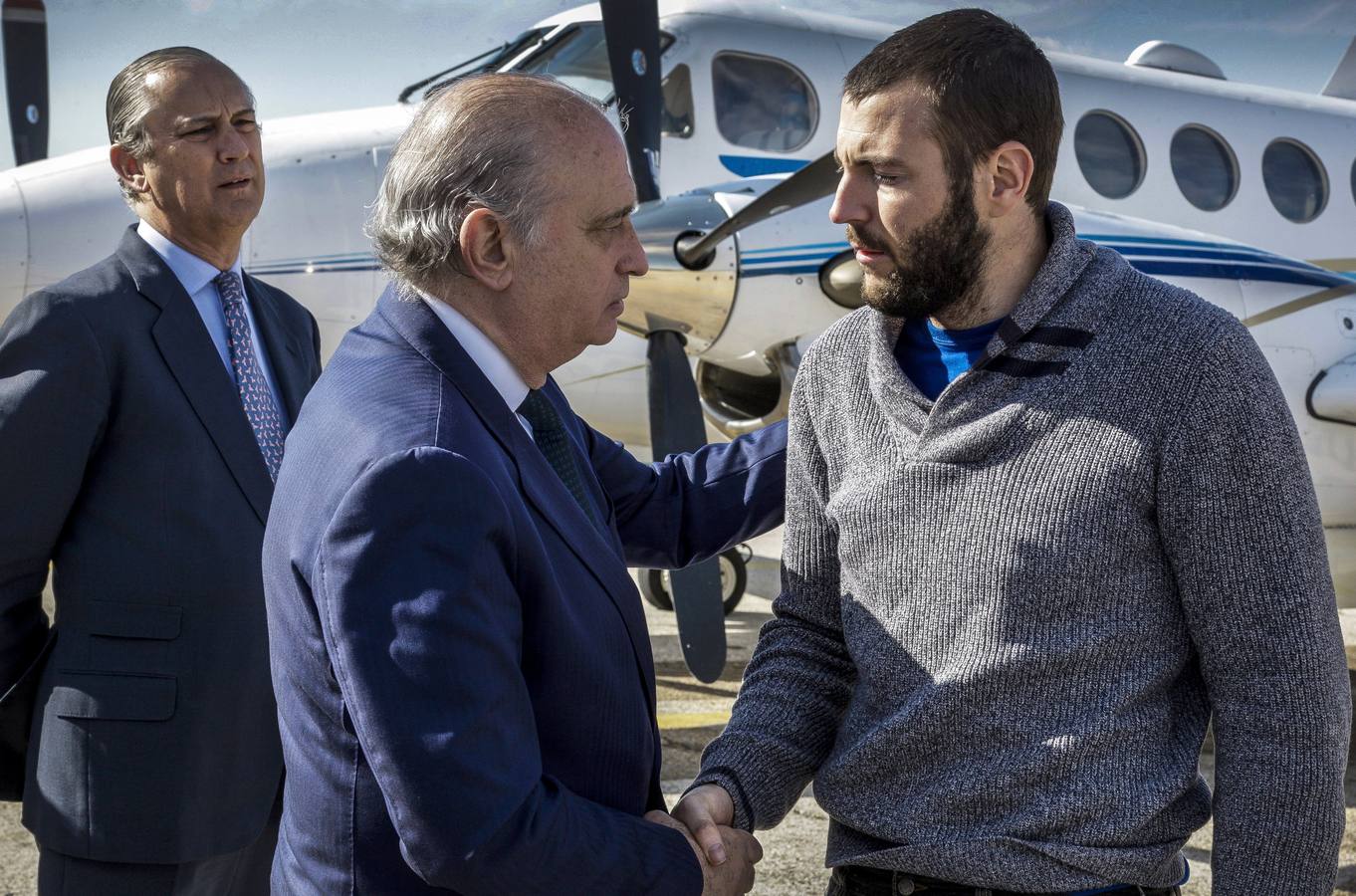 Martes, 7 de abril. Jorge Fernández Díaz (c), recibiendo al policía nacional y espeleólogo Juan Bolívar Bueno (d), a su llegada al aeródromo de Cuatro Vientos de Madrid, procedente de Uarzazate (Marruecos), en el avión fletado por la Policía tras el accidente en el que fallecieron otro agente y un abogado españoles. Fotografías: EFE