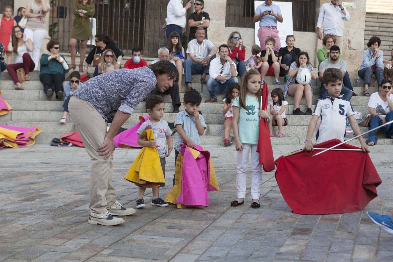 Jueves, 14 de mayo: El matador de toros cacereño Manolo Bejarano dirigió en la Plaza Mayor de Cáceres, una clase práctica de toreo de salón en la que participaron decenas de niños que, asidos a sus muletas y capotes, deleitaron a cuantos se acomodaron en las escaleras del Arco de la Estrella para contemplar tan inusual estampa. Fotografías: Jorge Rey