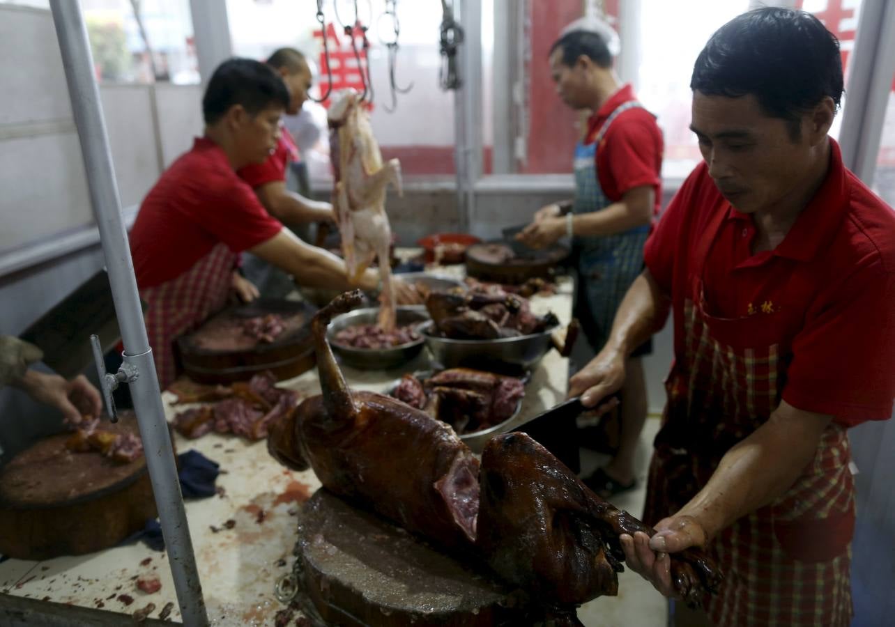 Lunes, 22 de junio. En el mercado, algunos perros se venden como mascotas, mientras que en otros se venden como carne para consumo humano. En la fiesta local de la ciudad de Yulin (China) es costumbre consumir carne de perro y lichis en la celebración del solsticio de verano. Fotografías: Kim Kyung-Hoon