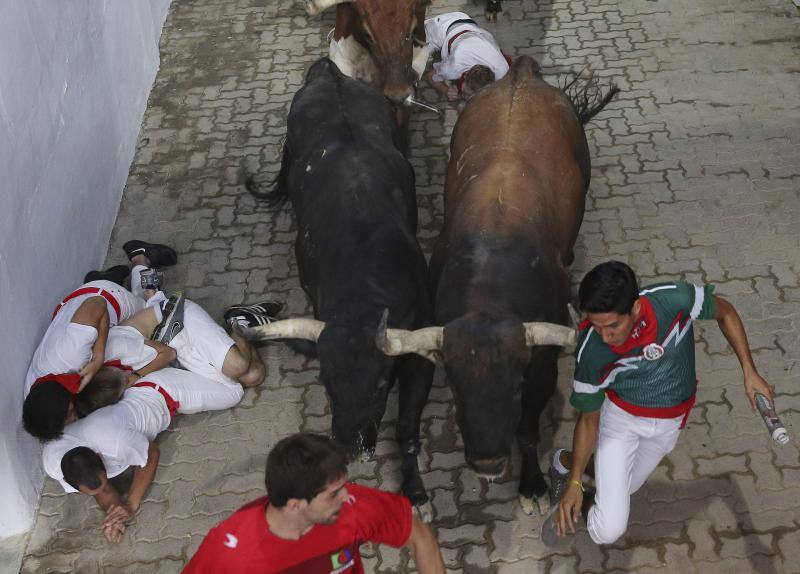 Los mosos intentan evitar ser alcanzados por el toro.