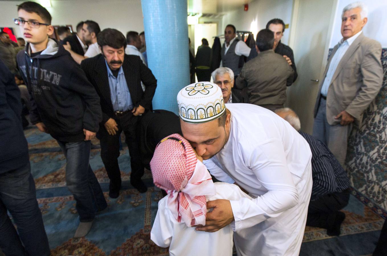 Un padre besa hijo después de tomar parte en las oraciones del Eid al-Fitr en la mezquita Mevlavana en Rotterdam.