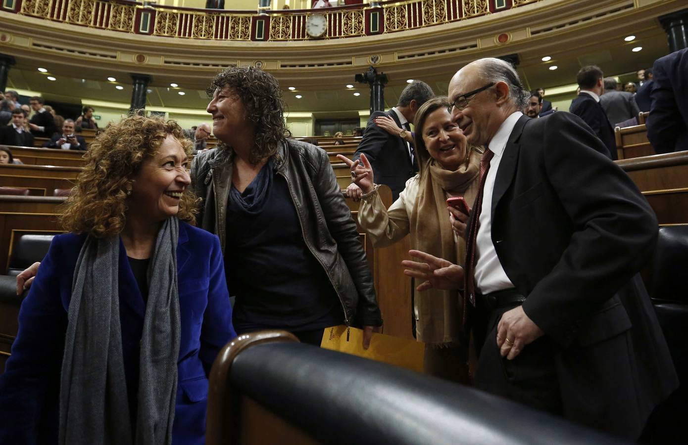 El ministro de Hacienda en funciones, Cristóbal Montoro, conversa con unas diputadas en el hemiciclo.