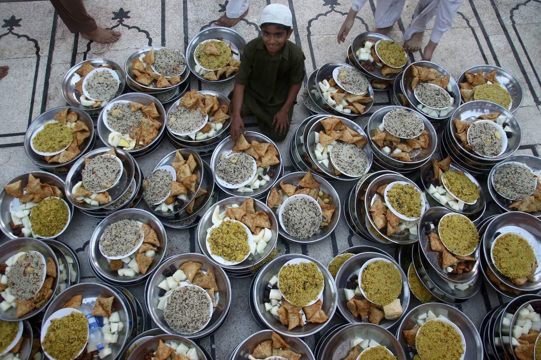 Un hombre sirve comida a los participantes para el Iftar, el momento para romper el ayuno, durante la celebración del Ramadán en Karachi (Pakistán)