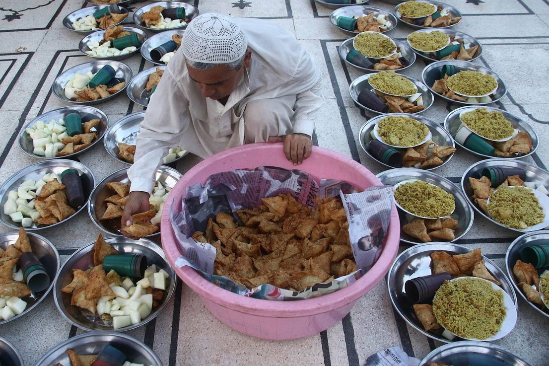 Un hombre sirve comida a los participantes para el Iftar, el momento para romper el ayuno, durante la celebración del Ramadán en Karachi (Pakistán)