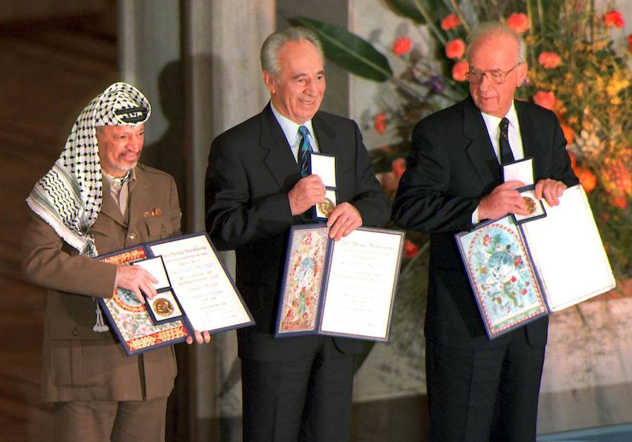 Yasser Arafat, Simon Peres e Isaac Rabin, galardonados con el Premio Nobel de la Paz 1994, posan con los respectivos documentos.