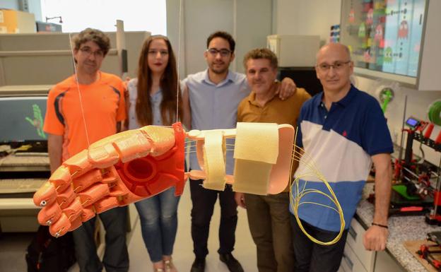 El equipo de ExtreMakers y Sirok posa al fondo de uno de los prototipos de la mano de Dani.