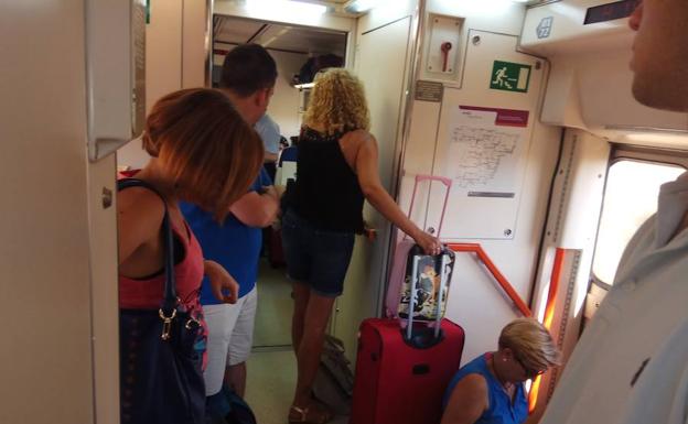 Viajeros de pie en el tren que recogió el domingo a los que se bajaron de otro que paró en Torrijos. 