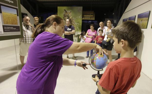 La monitora Sayaka Fernández da explicaciones sobre astronomía a visitantes del centro de interpretación.