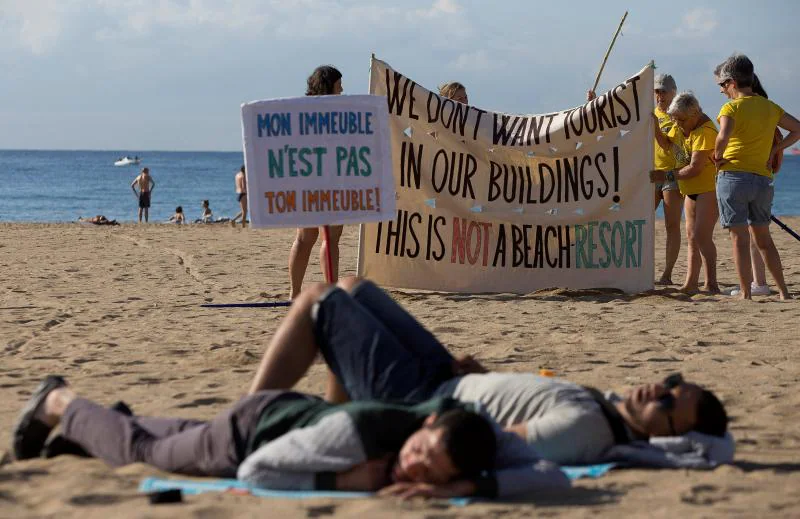 Varias personas protestan en una playa en Barcelona.