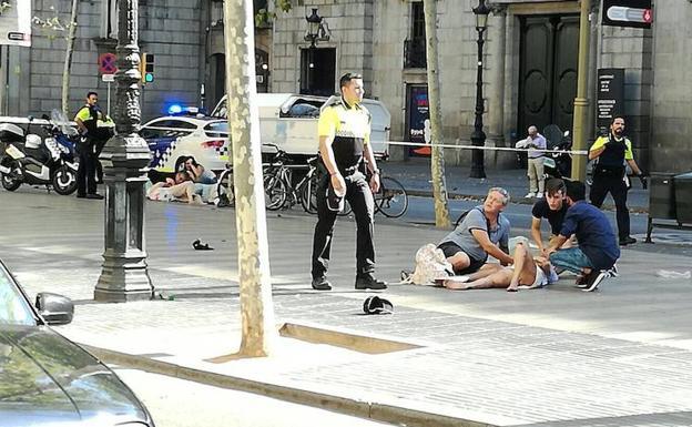 Transeuntes atienden a una de las personas heridas.