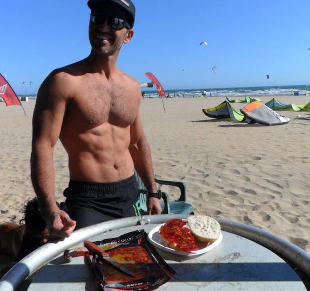 Nacho Artero, cuyos padres son de Cáceres, merendando chorizo en la playa de Punta Umbría.