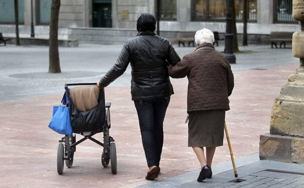 Imagen de archivo de una cuidadora con una mujer dependiente durante un paseo. :: hoy