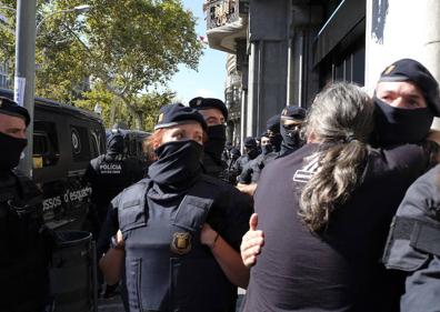 Imagen secundaria 1 - Varios mossos y manifestantes tras los registros.
