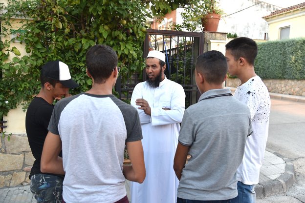 El presidente del centro islámico charla con un grupo de jóvenes en una calle de Talayuela. :: david palma