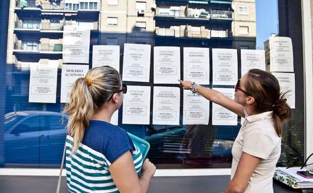 Imagen de archivo de dos opositoras mirando las listas de empleo público del SES.
