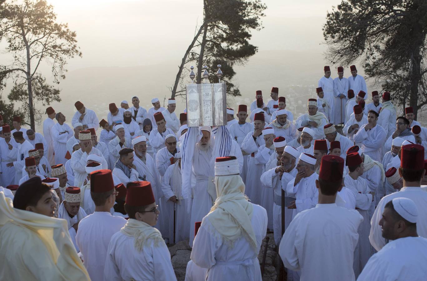 Miembros de la comunidad samaritana caminan hacia la cima del Monte Guerizín al amanecer en Nablus (Palestina), con motivo de la celebración del Sukot o fiesta de los tabernáculos.