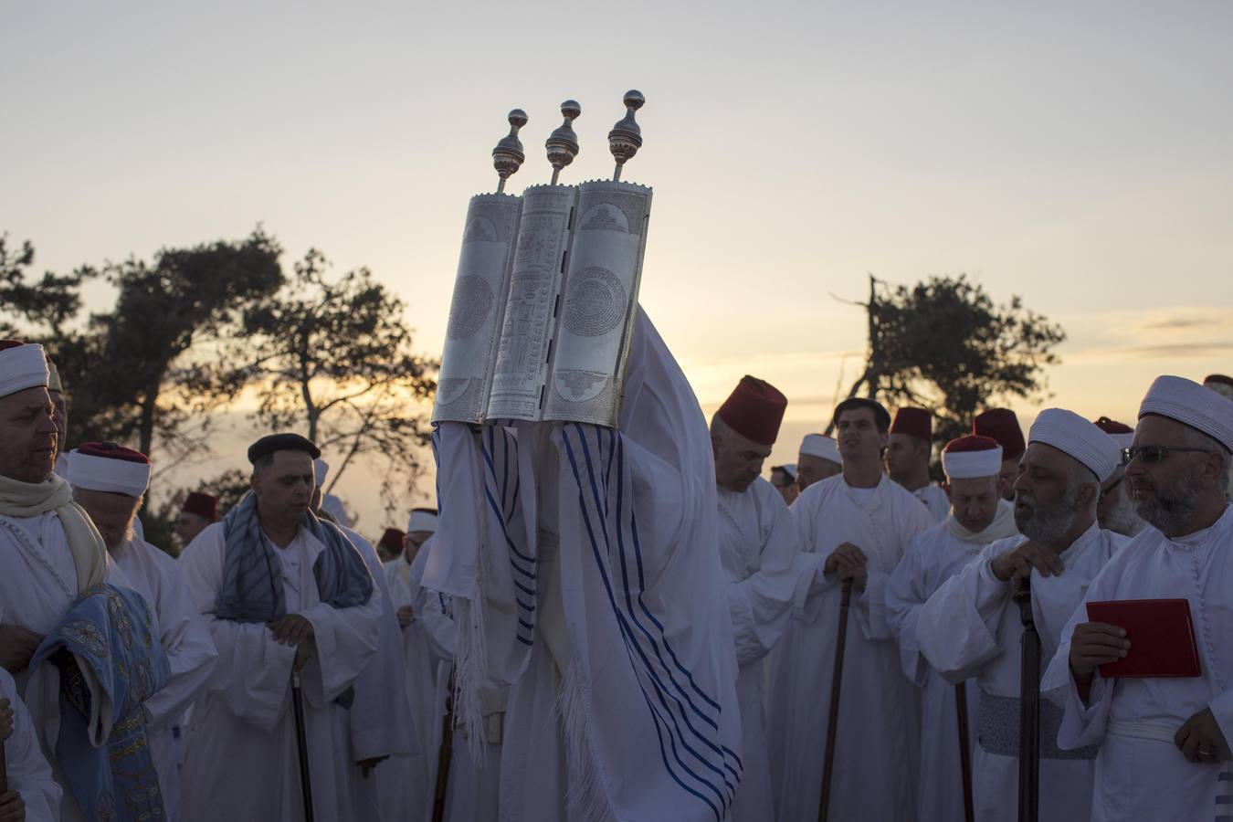 Miembros de la comunidad samaritana caminan hacia la cima del Monte Guerizín al amanecer en Nablus (Palestina), con motivo de la celebración del Sukot o fiesta de los tabernáculos.