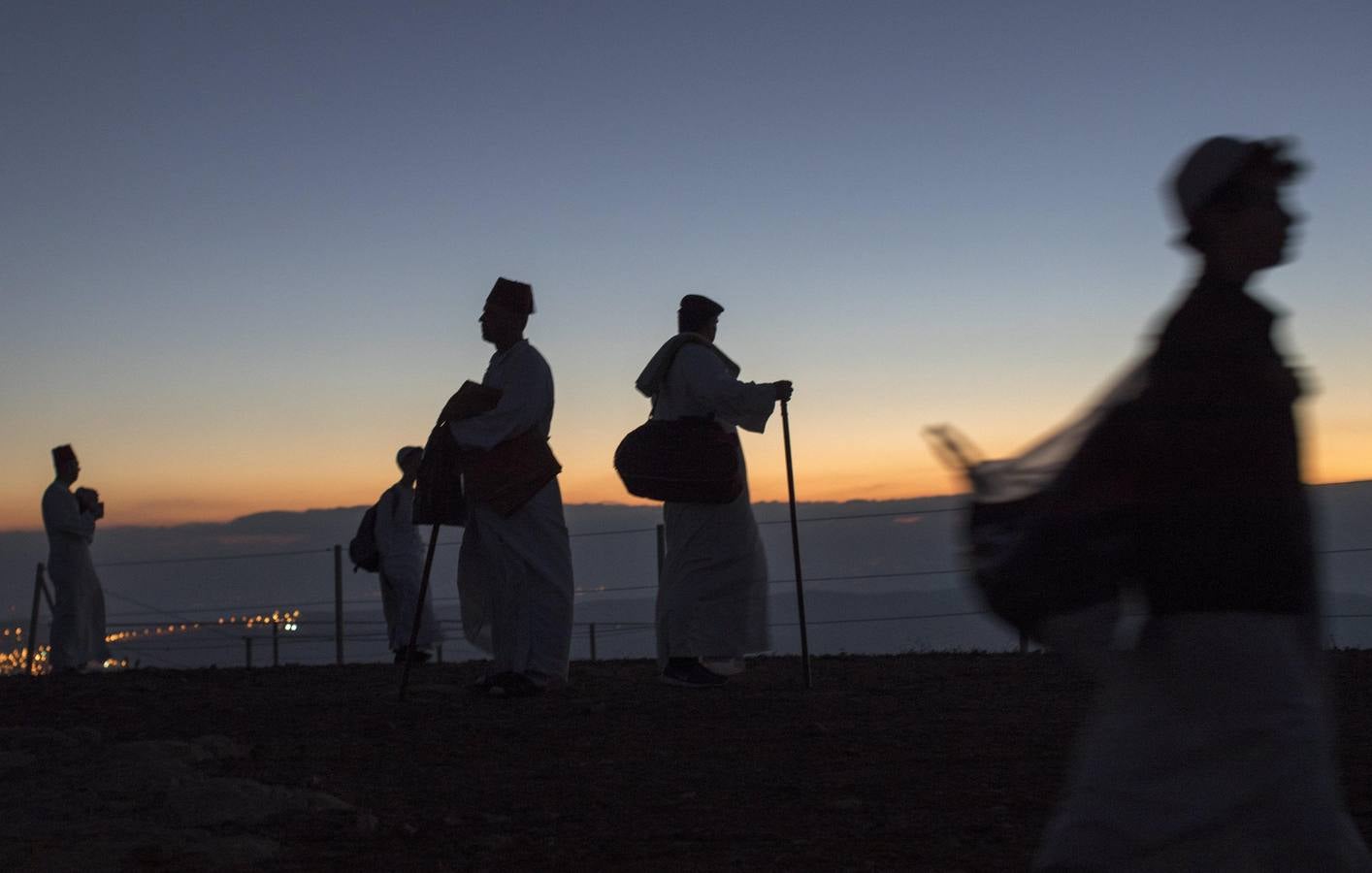 Miembros de la comunidad samaritana caminan hacia la cima del Monte Guerizín al amanecer en Nablus (Palestina), con motivo de la celebración del Sukot o fiesta de los tabernáculos.