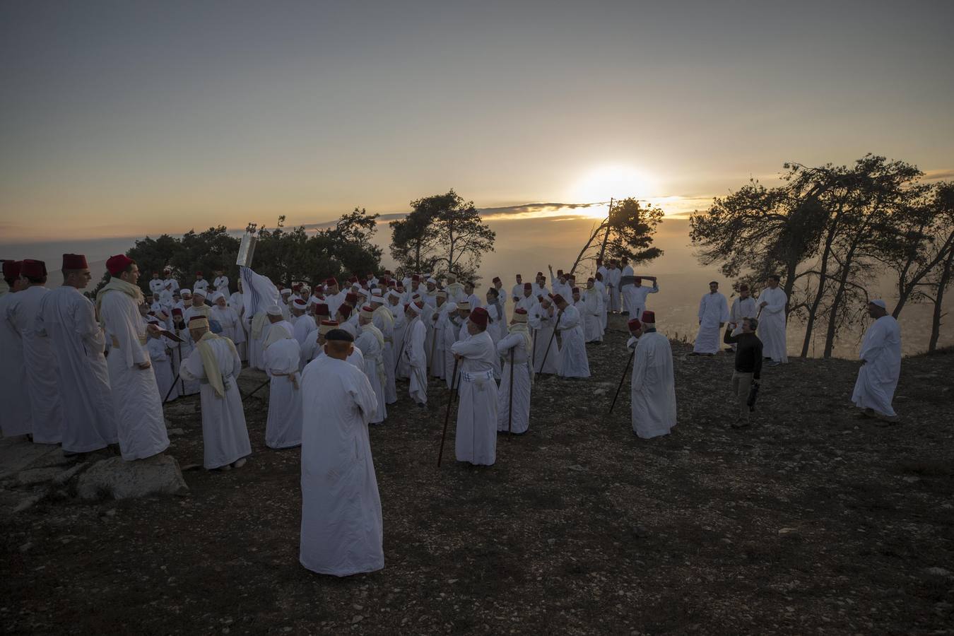 Miembros de la comunidad samaritana caminan hacia la cima del Monte Guerizín al amanecer en Nablus (Palestina), con motivo de la celebración del Sukot o fiesta de los tabernáculos.