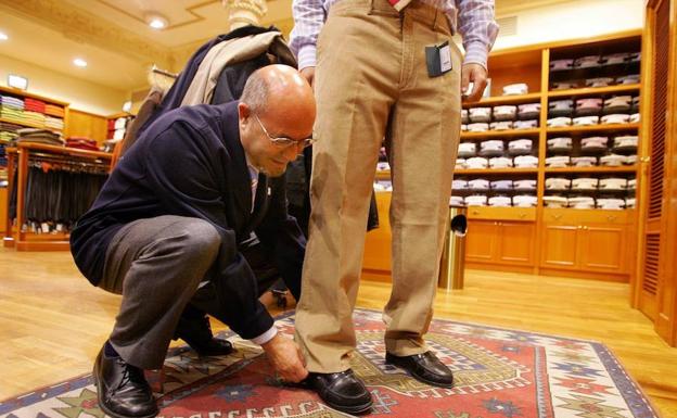 Un dependiente atiende a un cliente en una tienda de ropa:: HOY