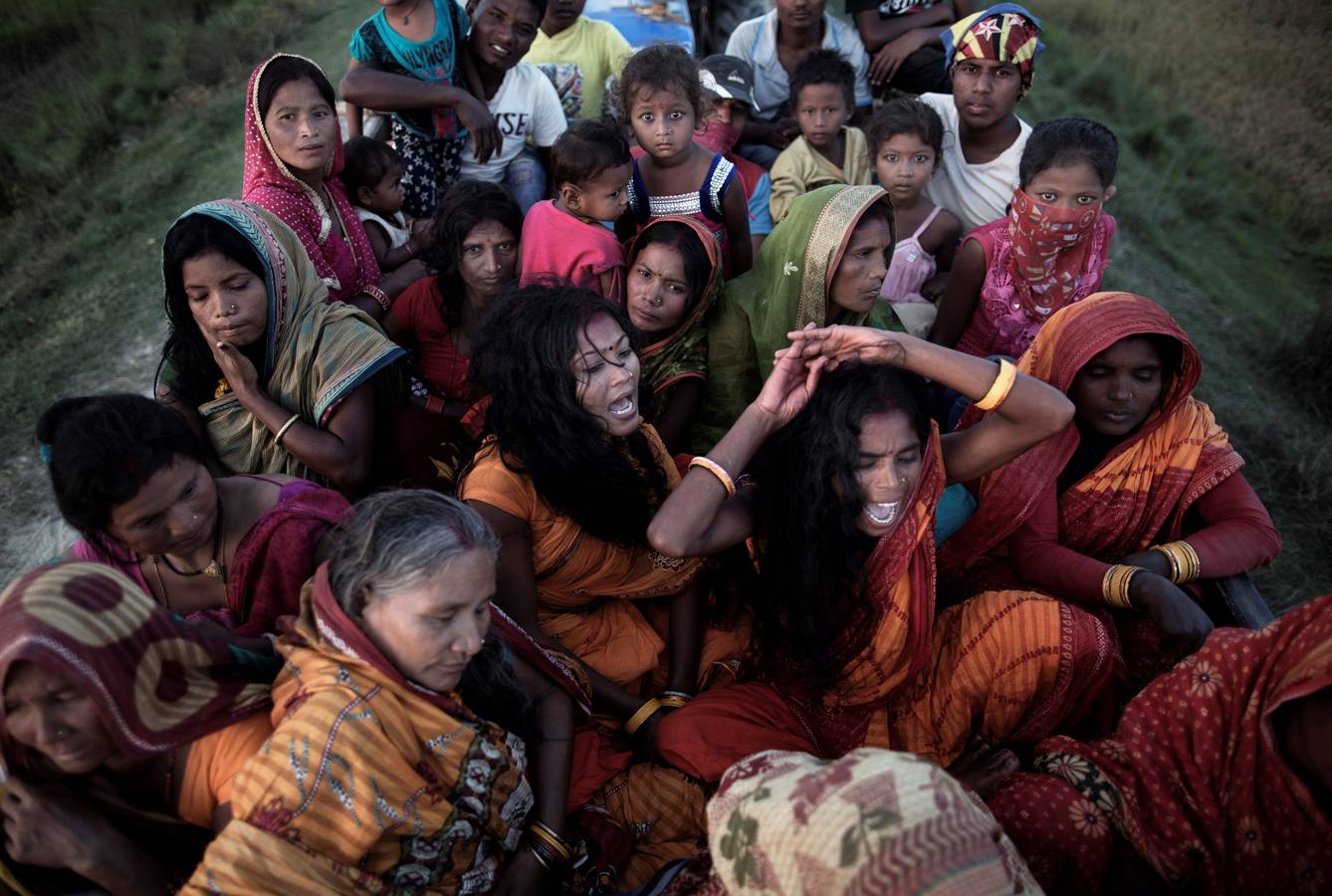 Un grupo de mujeres que creen haber sido poseídas por espíritus malignos danzan y cantan mantras en la víspera de una noche de luna llena, mientras se congregan para la celebración del "Festival de los fantasmas", en las orillas del río Kamala en el distrito de Danusha (Nepal), el 3 de noviembre de 2017. La celebración tiene siglos de tradición y tiene lugar anualmente en la noche de luna llena de noviembre. Miles de personas se congregan para llevar a cabo rituales de sanación conducidos por chamanes, en los que se "cura" a personas poseídas de espíritus malignos que acechan el porvenir de las familias.
