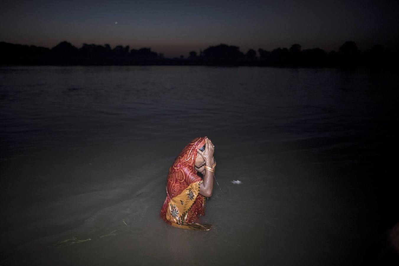 Un grupo de mujeres que creen haber sido poseídas por espíritus malignos danzan y cantan mantras en la víspera de una noche de luna llena, mientras se congregan para la celebración del "Festival de los fantasmas", en las orillas del río Kamala en el distrito de Danusha (Nepal), el 3 de noviembre de 2017. La celebración tiene siglos de tradición y tiene lugar anualmente en la noche de luna llena de noviembre. Miles de personas se congregan para llevar a cabo rituales de sanación conducidos por chamanes, en los que se "cura" a personas poseídas de espíritus malignos que acechan el porvenir de las familias.