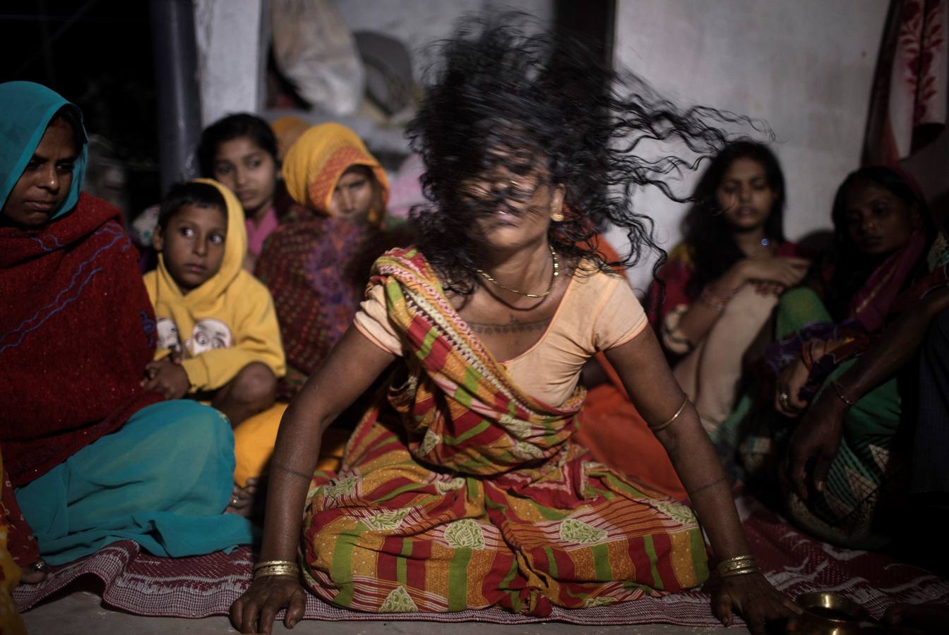 Un grupo de mujeres que creen haber sido poseídas por espíritus malignos danzan y cantan mantras en la víspera de una noche de luna llena, mientras se congregan para la celebración del "Festival de los fantasmas", en las orillas del río Kamala en el distrito de Danusha (Nepal), el 3 de noviembre de 2017. La celebración tiene siglos de tradición y tiene lugar anualmente en la noche de luna llena de noviembre. Miles de personas se congregan para llevar a cabo rituales de sanación conducidos por chamanes, en los que se "cura" a personas poseídas de espíritus malignos que acechan el porvenir de las familias.