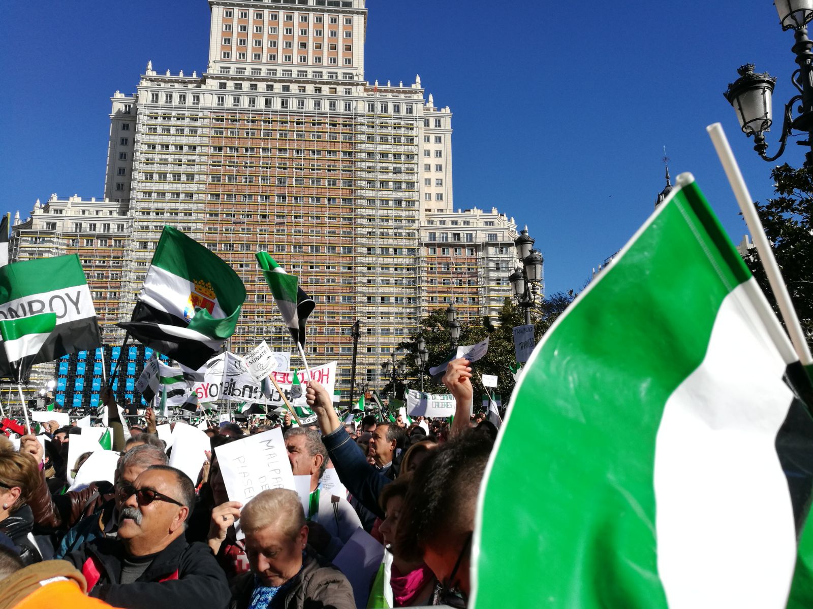 Miles de extremeños exhibiendo pancartas reivindicativas y banderas extremeñas llenan la plaza de España en la concentración por el #trendignoya