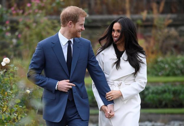 Enrique y Meghan posan sonrientes en los jardines de Kensington, ayer, tras anunciar su compromiso. :: reuters