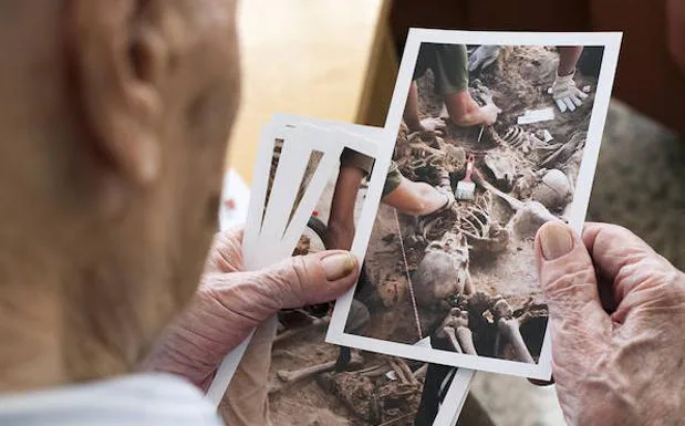Francisco viendo una de las fotografías que su nieta hizo durante las exhumaciones. Nunca imaginó que viviera para verlo.