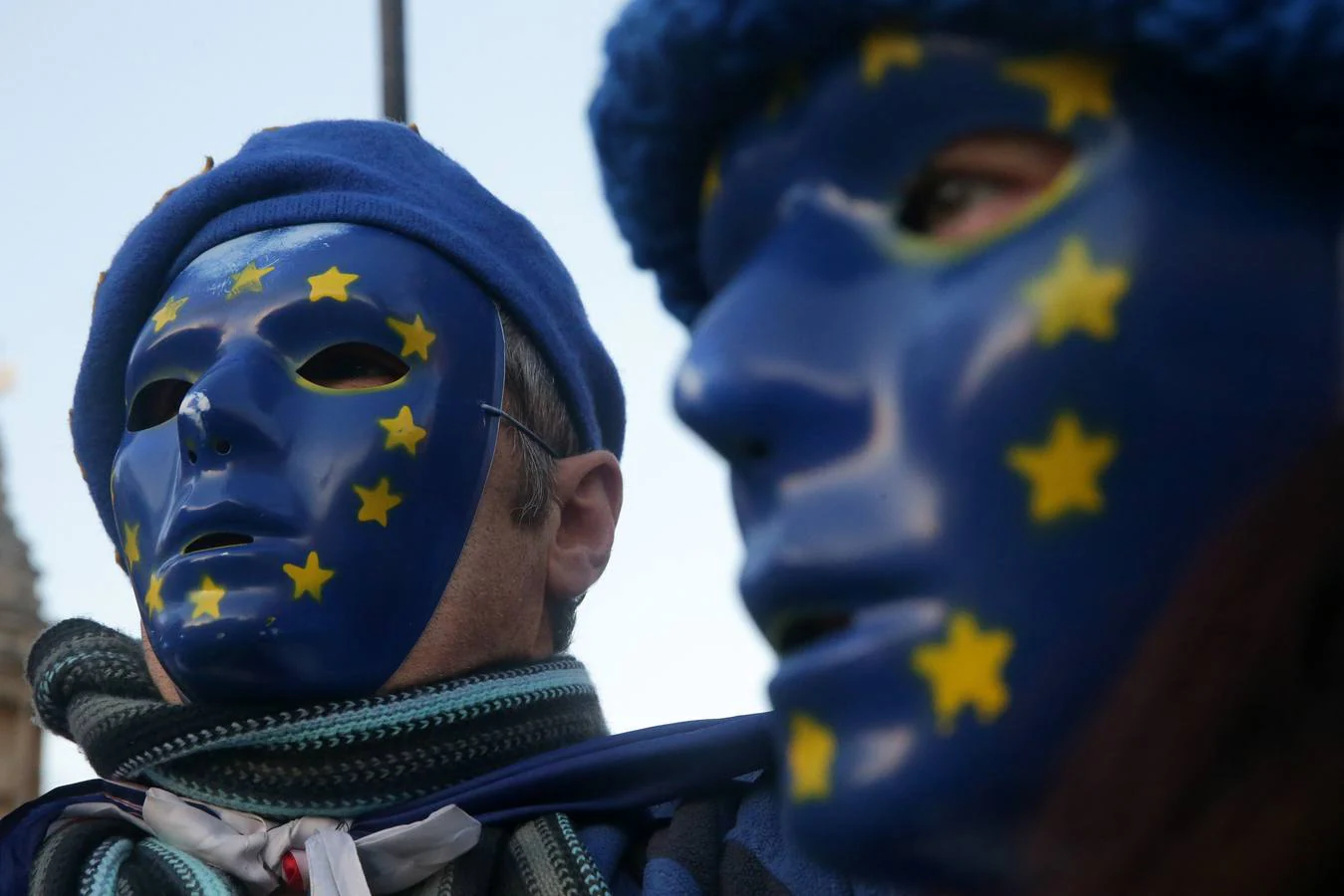 Los manifestantes pro-Unión Europea, (UE) y anti-Brexit usan máscaras con la bandera de la UE, ya que sostienen una bandera de la Unión fuera del Parlamento en el centro de Londres el 18 de diciembre de 2017. / AFP PHOTO / 