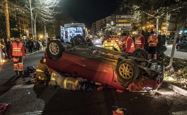 Bomberos intentando sacar a la víctima del coche siniestrado::