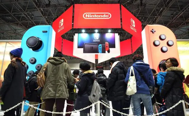 Varios usuarios, frente a un stand de Nintendo.