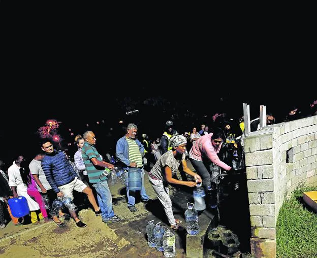 Vecinos de Ciudad del Cabo hacen cola junto a las fuentes de agua potable en busca de suministro. :: reuters