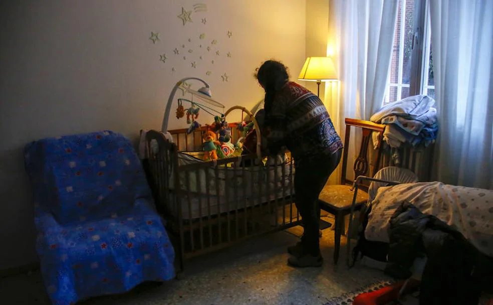 Una madre atiende a su pequeño en el piso de acogida que le ha facilitado la Fundación Madrina en Madrid