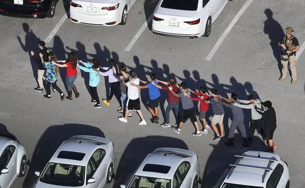 Los alumnos salen en fila del campus de Parkland tras la amtanza