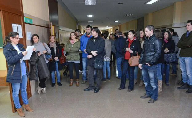 Aspirantes esperan a entrar en el aula para hacer las oposiciones del SES en 2014