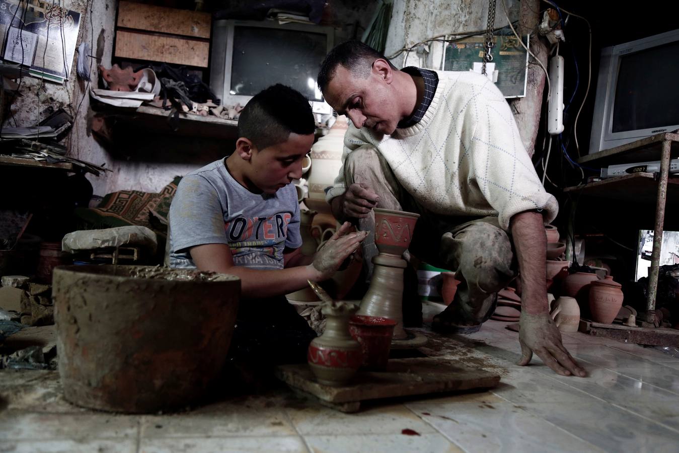 El palestino Jamal Fakhori y su hijo hacen vasijas de arcilla en su taller en la ciudad de Jaba, cerca de Jenin, en la ocupada Cisjordania