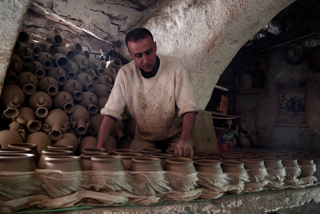 El palestino Jamal Fakhori y su hijo hacen vasijas de arcilla en su taller en la ciudad de Jaba, cerca de Jenin, en la ocupada Cisjordania