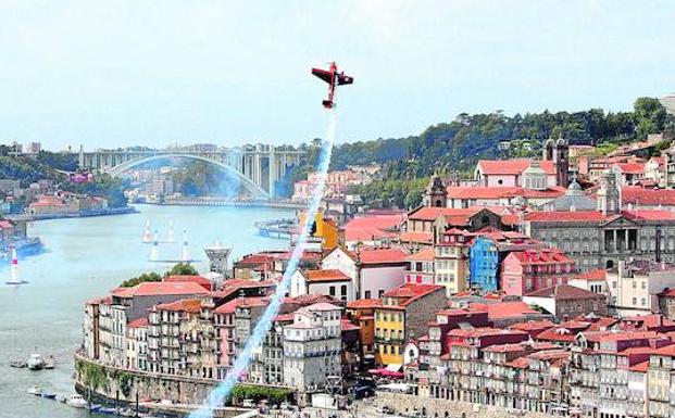 Una avioneta hace una espectacular acrobacia sobre el río Duero, a su paso por Oporto. :: joau a. miranda