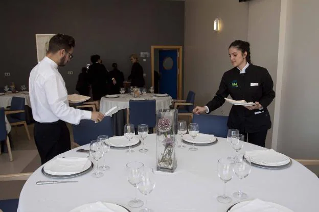 Dos camareros montan las mesas para las comidas de los jueves a mediodía. :: j. m. romero