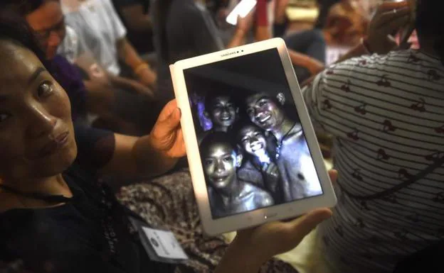 Familiares muestran fotos de los niños atrapados en la cueva.