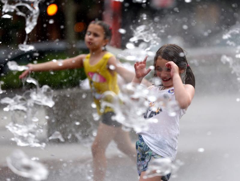 Dos niñas se refrescan ayer en Boston, dónde también sufren la ola de calor que arrasa Canadá. 