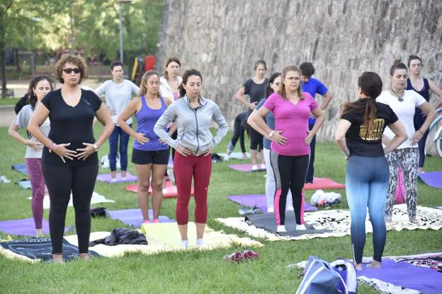 Practicantes de yoga en una clase al aire libre en el parque infantil de Badajoz. :: HOy