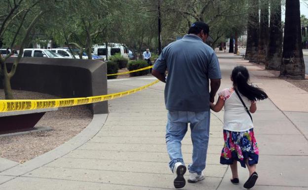 Un hombre camina junto a su hija tras salir de una cita en la Oficina de Control de Inmigración y Aduanas en Phoenix (Arizona).