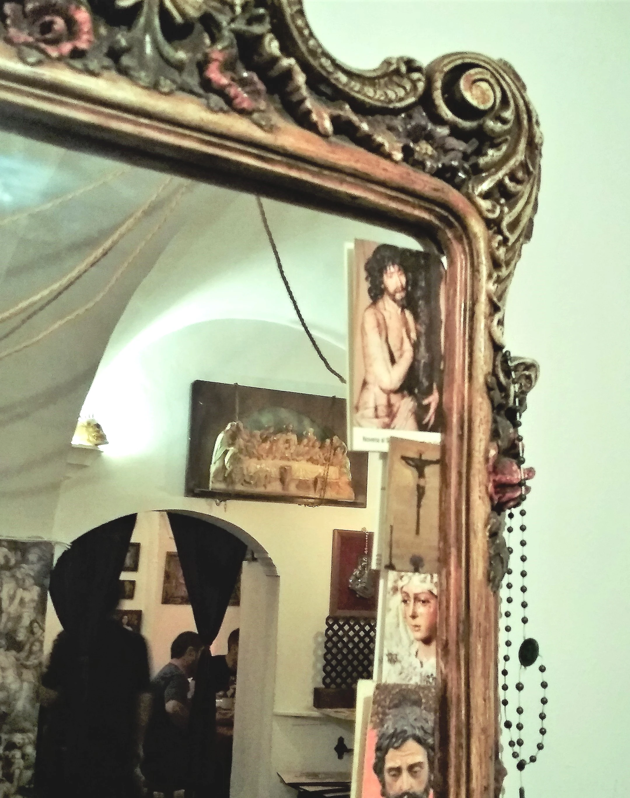 Interior de la tapería 'Trinidad' con la imagen del Cristo de Serradilla colocada en el marco de un espejo.