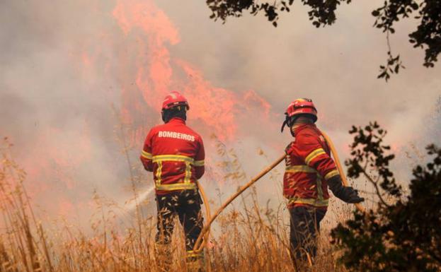 Bomberos tratan de extinguir las llamas del incendio en el Algarve portugués. 